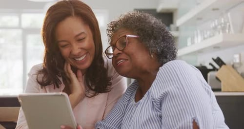 Smiling Women Use Tablet in Bright Kitchen