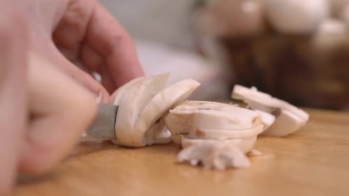 Close up of mushrooms being sliced on cutting board