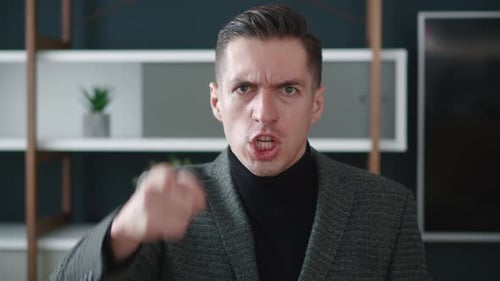 Furious man yelling and pointing into the camera