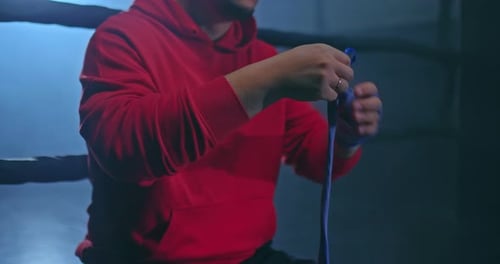 Closeup a Male Fighter Wraps His Fingers in Protective Bandages Before a Fight a Dark Gym in Smoke