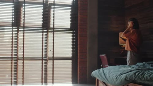 Woman Using Smartphone in Modern Sun-Filled Loft