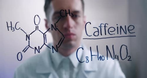 Scientist Writes Chemical Formula for Caffeine on Glass