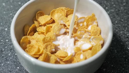 Milk Pouring into Bowl of Golden Corn Flakes