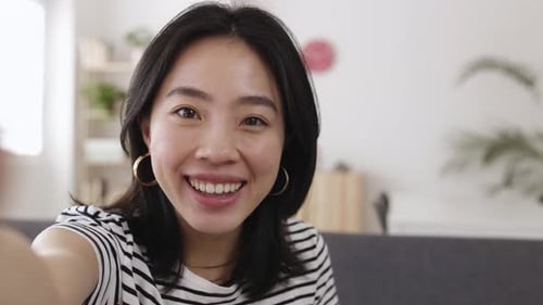 Smiling Woman Waving During a Video Call