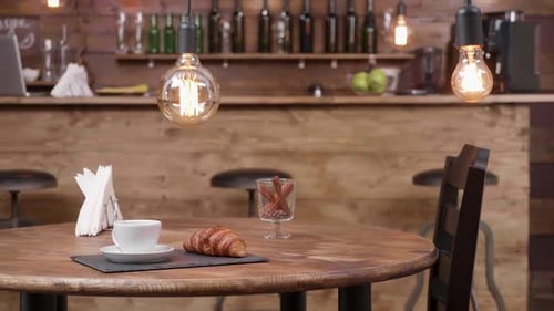 Slide Shot From Right To Left of a Coffee Shop Table with a Cup of Coffee on It