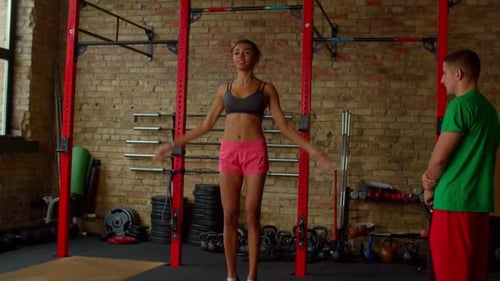 Athletic Woman Exercising at Gym with Personal Trainer