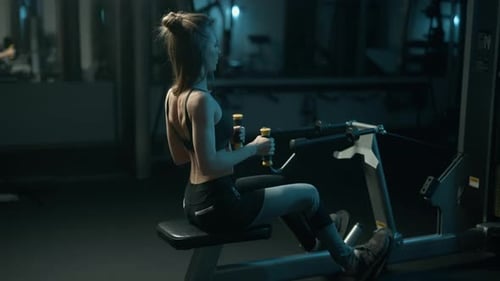 A Pretty Athletic Fit Woman is Doing Exercise on a Fitness Machine in the Gym Training Full Body