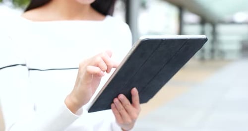 Frau nutzt Tablet im Freien