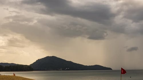 Dramatic Beach View with Dark Clouds at Sunset