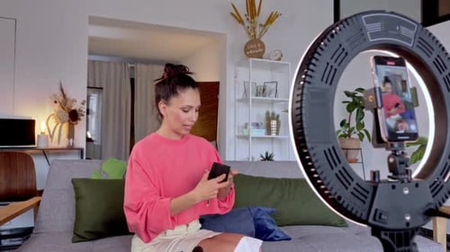 Tutorial de maquillaje de transmisión de influencers sentado en el sofá del estudio