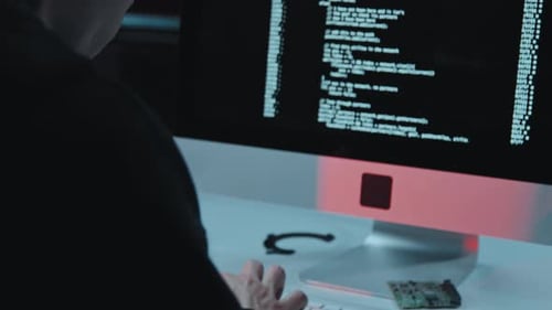 Man codiert oder hackt im dunklen Büro