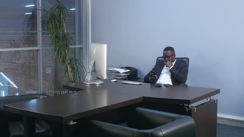 Young Afro American Businessman Browsing with Smartphone, Sitting in Office