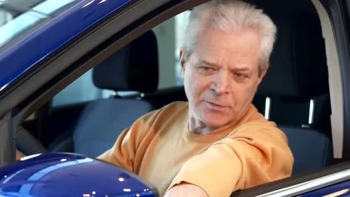 Senior Man Giving Thumbs Up in Blue Car
