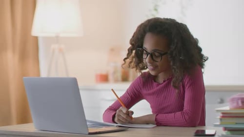 Girl Studying at Desk with Laptop and Notebook