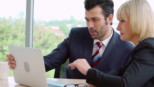 Two Business People Talk Project Strategy at Office