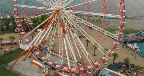 Aerial hyperlapse of Ferris wheel, alphabetic tower, skyscrapers and embankment of Batumi city