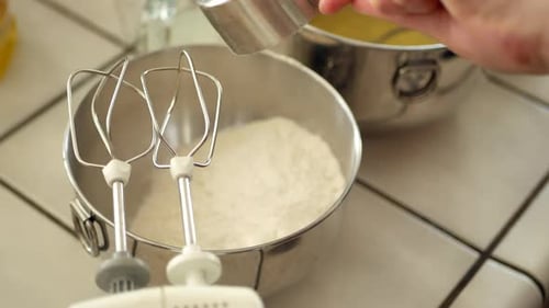 Der Küchenchef gießt Mehl in die Rührschüssel, während er in der