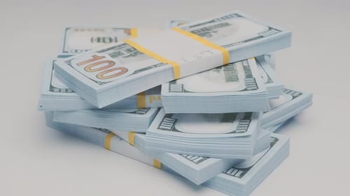 stack of bank bundles with dollars rotating on white background