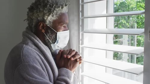 Man Wearing Mask Looking out Window