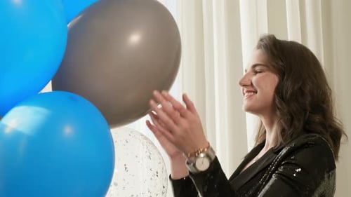 Close-up Beautiful Girl in Black Dress Fits the Blue Balloons