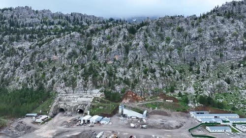 Heavy machinery drills tunnel through the mountain aerial view 4 K
