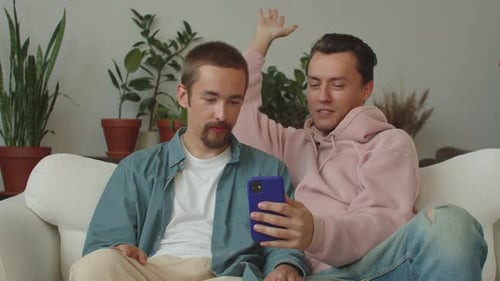 Two Young Men Relaxing with Mobile Phone at Home