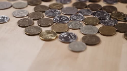 Scattered Coins on a Wooden Surface