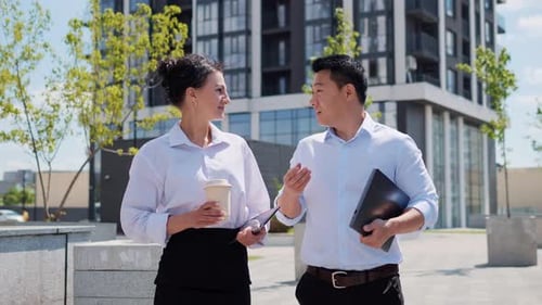 Geschäftsfrau und asiatischer Mann sprechen zusammen im Geschäftsviertel