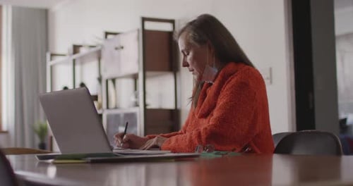 Woman Works on Laptop in Home Office