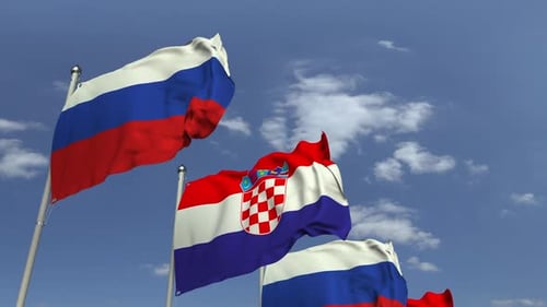 Waving Flags of Croatia and Russia Against Blue Sky
