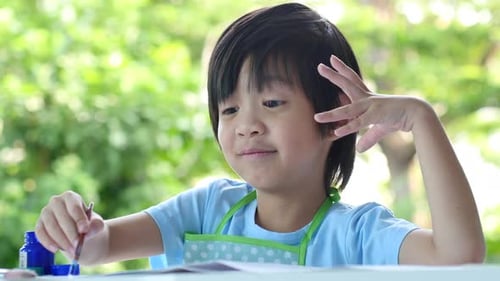 Young Child Painting Outside During Daytime