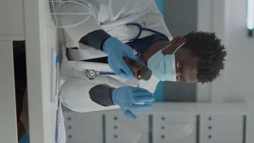 Focused Doctor Examining Prescription Bottle in Clinic