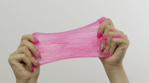 Woman Hands Playing Oddly Satisfying Pink Slime on White Background. Antistress