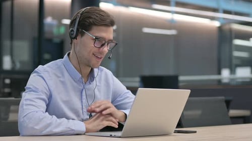 Man Wearing Headset in Video Conference at Desk