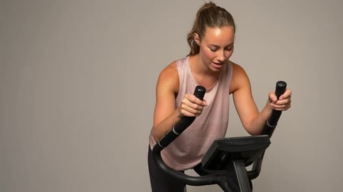 Woman Working Out on Stationary Bike Indoors