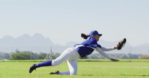 Jugadora de béisbol caucásica, jardinero atrapando y buceando con pelota en el campo de béisbol