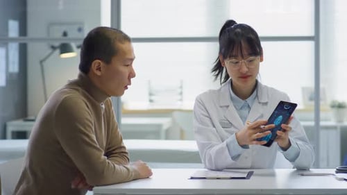 Doctor Explains Brain Scan on Tablet to Patient