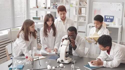 Science Class Studying Experiment Using Microscope