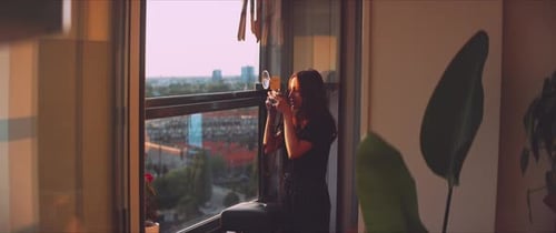 Woman Applies Makeup on City Apartment Balcony