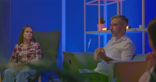 Un blogueur aux cheveux gris parle avec émotion dans un talk-show et gesticule une réunion dans un coworking