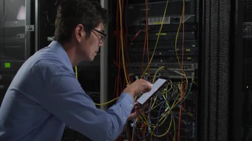 Man Using Tablet Inspecting Server Hardware