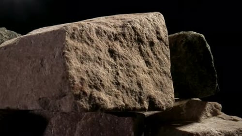 Stücke von massivem grobem Granitstein, die sich vor einem schwarzen Studiohinter