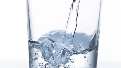 Water being poured into Glass against White Background, Slow Motion