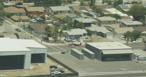 Helicopter aerial shot tracking backwards over green hills, sunlight streaming down, day