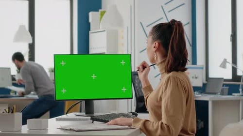 Colleagues Working Together with Green Screen on Computer Display