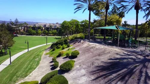 Aerial rotation from a park to a shopping mall with mountains in the background