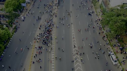 Aerial view. A crowd attends the car free day along street.