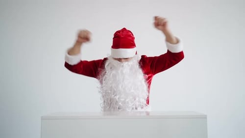 Santa Claus Dances Merrily Behind White Desk