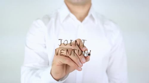 Writing Joint Venture With Marker on Clear Surface