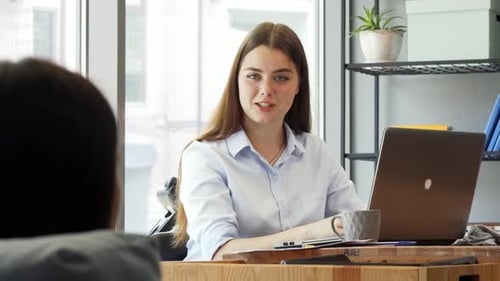Belle femme d'affaires joyeuse parlant à son collègue au travail